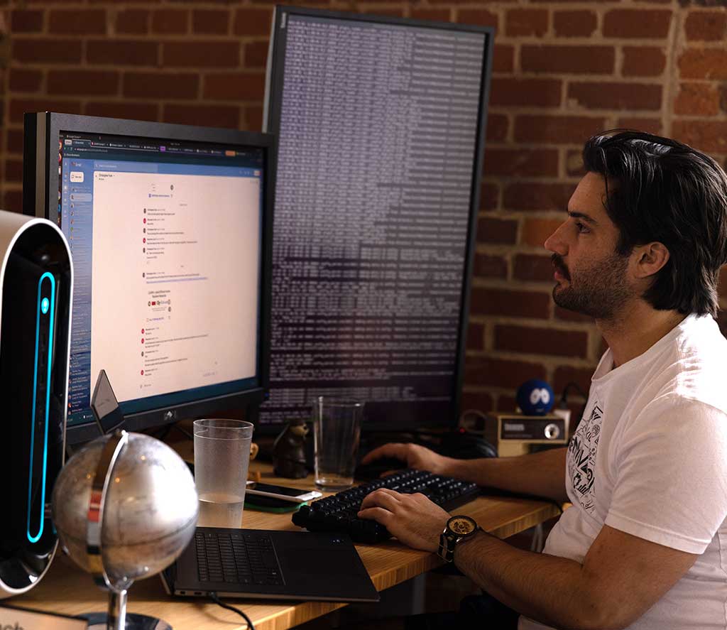 Person writing code on a desktop computer